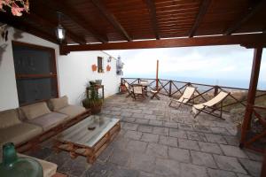 ein Wohnzimmer mit einer Couch und einem Tisch und Stühlen in der Unterkunft Bonita Casa Espectacular Vista in Acojeja