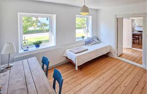 a room with a bed and a table and two windows at Beautiful Home In Ærøskøbing in Bro