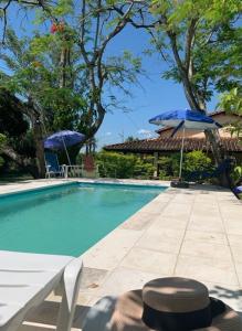 a person sitting in a chair next to a swimming pool at Casa de Verano en Ypacarai con lago natural, Piscina, Naturaleza y Comodidad para Grupos in Ypacarai