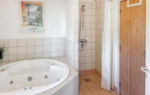 Un baño con bañera grande y ducha. en Amazing Apartment In Faaborg With Sauna, en Nabbe