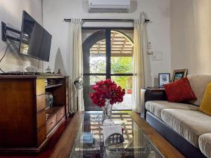 a living room with a vase of flowers on a glass table at Casa de Verano en Ypacarai con lago natural, Piscina, Naturaleza y Comodidad para Grupos in Ypacarai