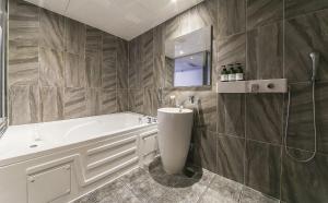 a bathroom with a tub and a sink at Nampo MGM Hotel in Busan +92 photos