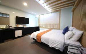 a bedroom with a bed and a flat screen tv at Nampo MGM Hotel in Busan +3 photos
