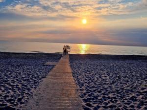 a person walking on a pier on the beach at 5 person holiday home in Jerup-By Traum in Jerup