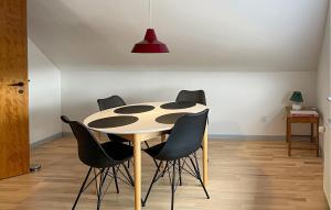 a dining room with a table and black chairs at 1 Bedroom Cozy Apartment In Hesselager in Hesselager