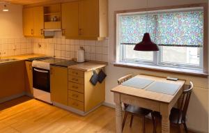 a kitchen with a wooden table and a table and a table at 1 Bedroom Cozy Apartment In Hesselager in Hesselager