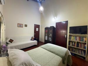 a room with two beds and a book shelf at Casa de Verano en Ypacarai con lago natural, Piscina, Naturaleza y Comodidad para Grupos in Ypacarai