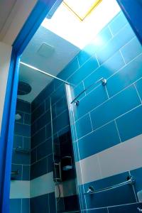a bathroom with a shower with blue tile at Magnifique appartement de style Catalan, au bord de la Plage du Grand Large pour location de vacances, de week-end, de nuité à Canet-en-Roussillon in Canet-en-Roussillon +9 photos