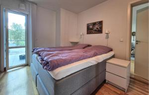a bedroom with a bed with a purple blanket on it at Awesome Apartment In Ulvik With House Sea View in Ulvik