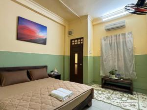 a bedroom with a bed and a picture on the wall at An Homestay 2 in Phan Thiet