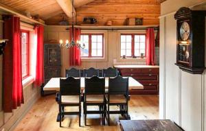 a dining room with a table with chairs and a clock at Stunning Home In Oppdal With Sauna in Fagerhaug