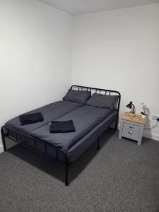 a bedroom with a black bed with a night stand at Quality Rooms in Liverpool +24 photos