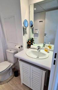 ein Badezimmer mit Waschbecken, Toilette und Spiegel in der Unterkunft L'Escale - Double matelas - Clim - Wifi in Lourdes