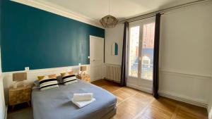 a bedroom with a large bed with a blue wall at POITTE - Appartement Rennes 10P in Rennes
