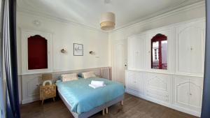 a bedroom with a blue bed and white walls at POITTE - Appartement Rennes 10P in Rennes