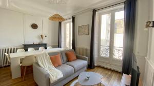 a living room with a couch and a table at POITTE - Appartement Rennes 10P in Rennes