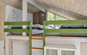 a bedroom with two bunk beds in a tiny house at Lovely Home In Nørre Nebel With Sauna in Lønne Hede
