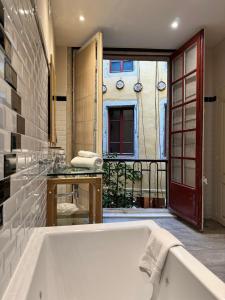 a bath tub in a bathroom with a balcony at Europe Hôtel in Castres