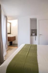 een slaapkamer met een bed en een badkamer met een wastafel bij La Chasse 5 in Brussel