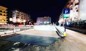 a city street at night with a parking lot at Nakupenda B&B in Cosenza