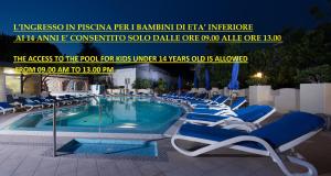 a blue and white swimming pool with chairs and umbrellas at Hotel San Felice in Capri