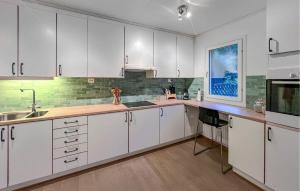 a kitchen with white cabinets and a sink at Cozy Home In Flekkefjord With House Sea View in Flekkefjord