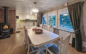 a kitchen and dining room with a table and a fireplace at Cozy Home In Flekkefjord With House Sea View in Flekkefjord