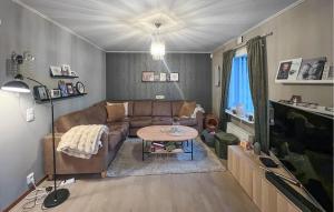 a living room with a couch and a table at Cozy Home In Flekkefjord With House Sea View in Flekkefjord +7 photos