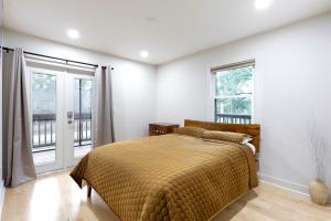 a bedroom with a bed and two windows at Group Retreat Fairhope in Fairhope