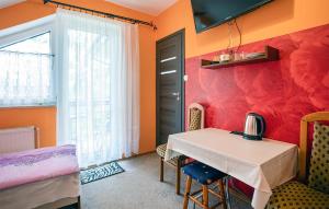 a dining room with a table and a red wall at Lovely Apartment In Jastrzebia Gora With Sauna in Tupadły