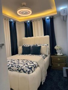 a bedroom with a white bed with black curtains at Lujoso apartamentos en boca chica in Cuevas