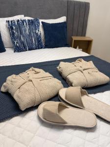 a pair of sandals and a pair of slippers on a bed at Lujoso apartamentos en boca chica in Cuevas