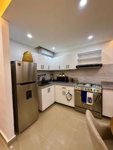 a kitchen with white cabinets and stainless steel appliances at Lujoso apartamentos en boca chica in Cuevas
