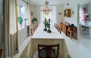 a dining room with a table with chairs and a chandelier at 3 Bedroom Stunning Home In Grebbestad in Grebbestad