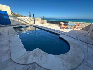 una piscina con el océano al fondo en Villa MANSOURA, en Driouch