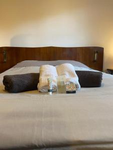 ein Bett mit zwei Kissen und zwei Kerzen darauf in der Unterkunft Mer & Bois de Cise Maison individuelle avec grand jardin in Ault