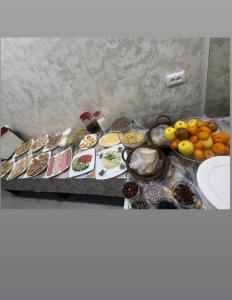 タシュケントにあるArt Dream Hotelのテーブルの上にさまざまな種類の食べ物が並んだビュッフェ +22枚の写真