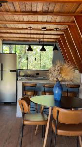 a kitchen with a table and chairs and a refrigerator at Chale Blue Lodge in São Pedro