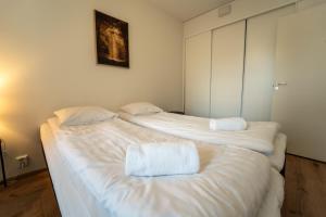 two beds in a room with white sheets and pillows at Snowflake X in Rovaniemi