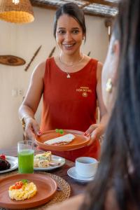 トランコーゾにあるPousada Por do Sol Trancosoの食卓を持つ女