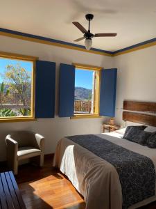 une chambre avec un lit et un ventilateur de plafond et deux fenêtres dans l'établissement Pousada Relíquias do Tempo, à Diamantina 196 autres photos