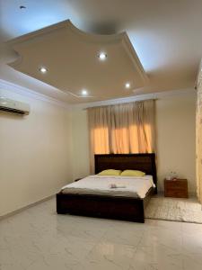 een slaapkamer met een groot bed en een raam bij Sultan Beach House in Muscat