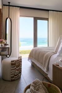 a bedroom with a bed and a view of the ocean at Nalu Villa in Cape Town