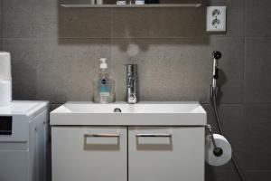 a bathroom with a sink with a bottle on it at Snowflake X in Rovaniemi