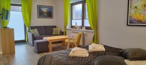 a living room with a bed and a couch and a table at Apartamety i Pokoje Gościnne Na Jaskółczej in Świeradów-Zdrój