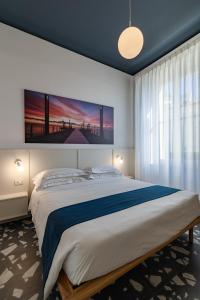 Un dormitorio con una cama grande con un cuadro en la pared. en Alaxia Exclusive Apartments, en Alassio