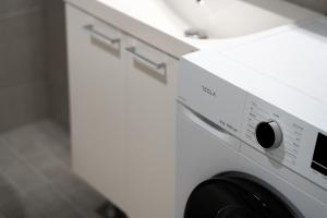 ロヴァニエミにあるSnowflake IXの- 白いランドリールーム(洗濯機、乾燥機付)