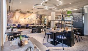 a restaurant with tables and chairs and a chalkboard at Sachsenpark-Hotel in Leipzig