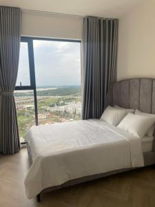 a bedroom with a large bed with a large window at 2BR Cozy Apartment- River and Park View- Masteri Centre Point - HCM in Ho Chi Minh City +16 photos