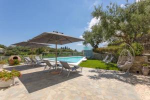 eine Terrasse mit Stühlen und Sonnenschirm und ein Pool in der Unterkunft Demargia Villa A - Loft Apartment in Áno Yerakaríon